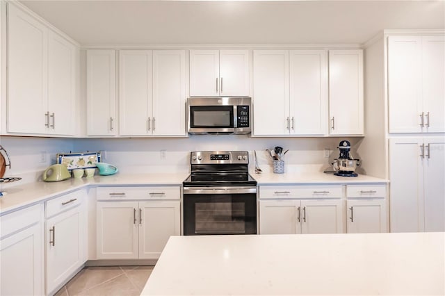 kitchen featuring white cabinetry, light tile patterned floors, and stainless steel appliances