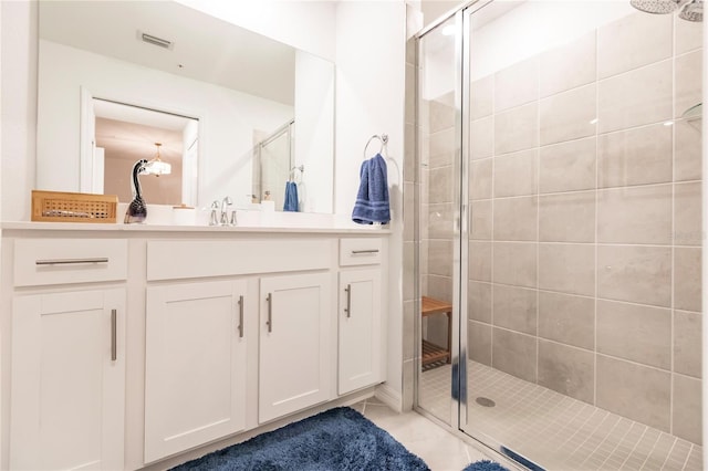 bathroom with tile patterned floors, vanity, and a shower with shower door