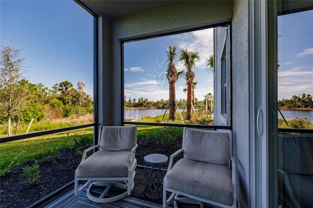 sunroom / solarium featuring plenty of natural light and a water view