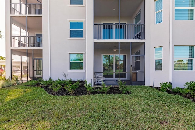 back of house with a balcony and a yard