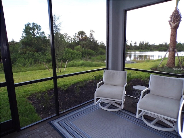 sunroom featuring a water view