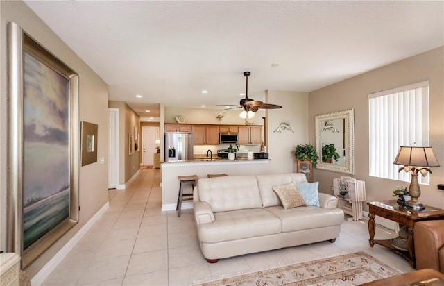 tiled living room featuring ceiling fan and sink