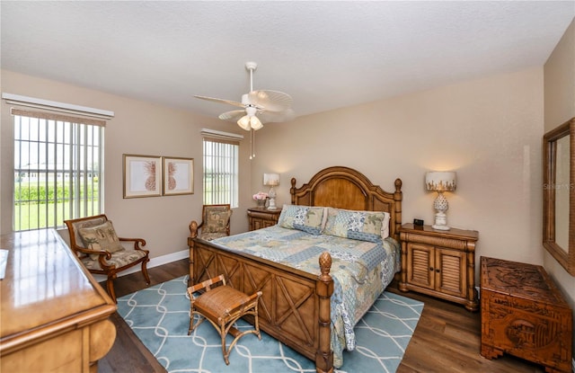 bedroom with ceiling fan, dark hardwood / wood-style floors, access to outside, and a textured ceiling