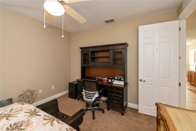 office space featuring ceiling fan, light colored carpet, and a textured ceiling