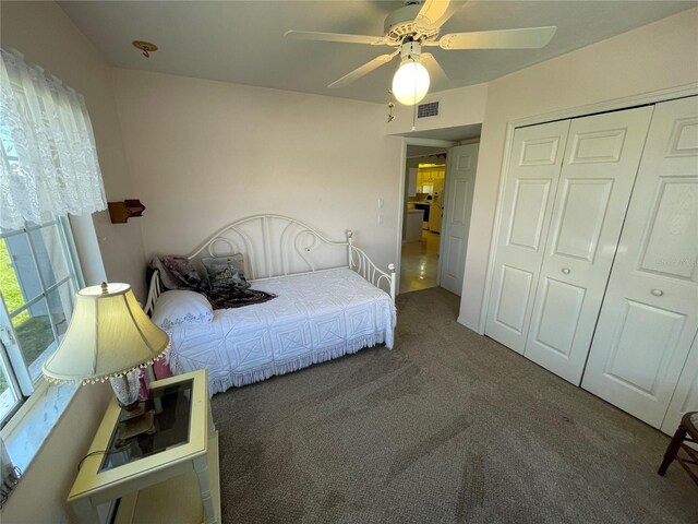 carpeted bedroom featuring ceiling fan and a closet