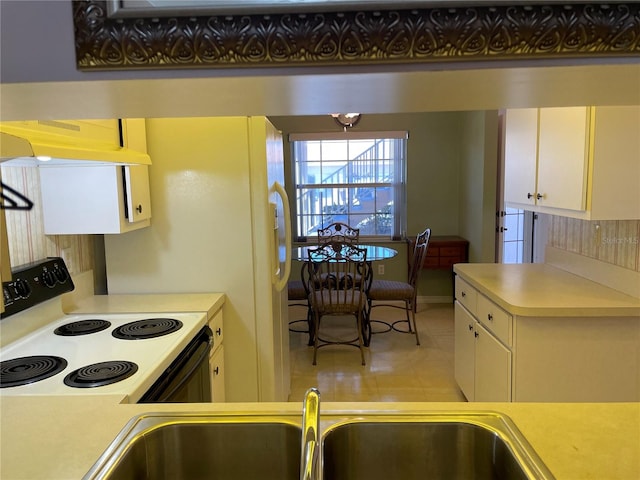 kitchen with light tile patterned flooring, range, and tasteful backsplash