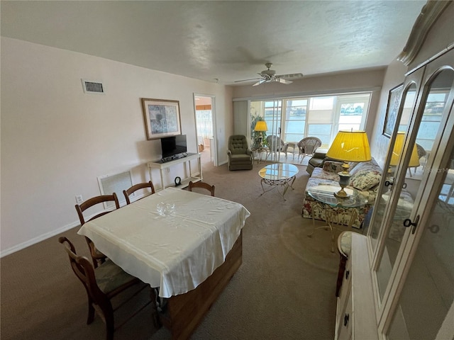 dining space with ceiling fan and light carpet