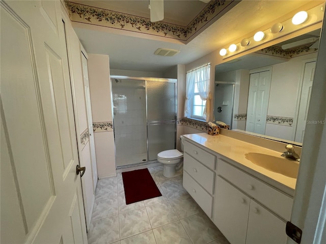 bathroom featuring tile patterned floors, toilet, an enclosed shower, and vanity