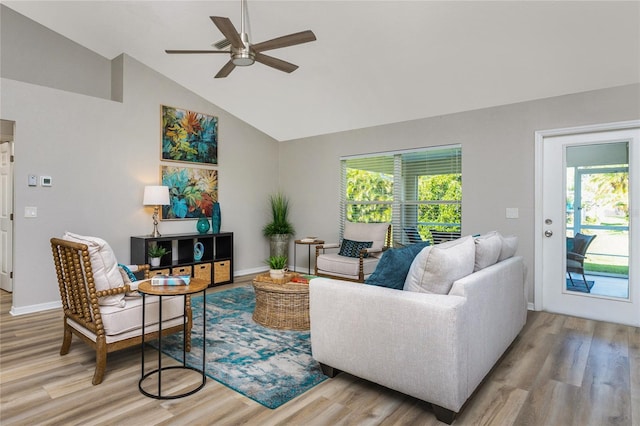 living room with ceiling fan, a wealth of natural light, vaulted ceiling, and light hardwood / wood-style flooring