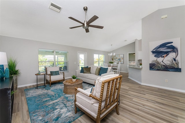 living room with light hardwood / wood-style flooring, high vaulted ceiling, and ceiling fan with notable chandelier