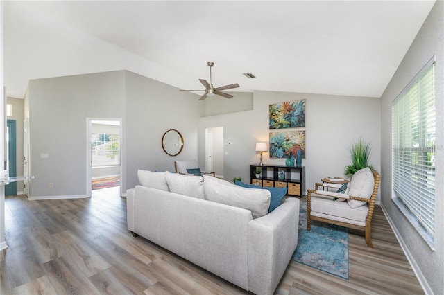 living room with light hardwood / wood-style floors, ceiling fan, and lofted ceiling