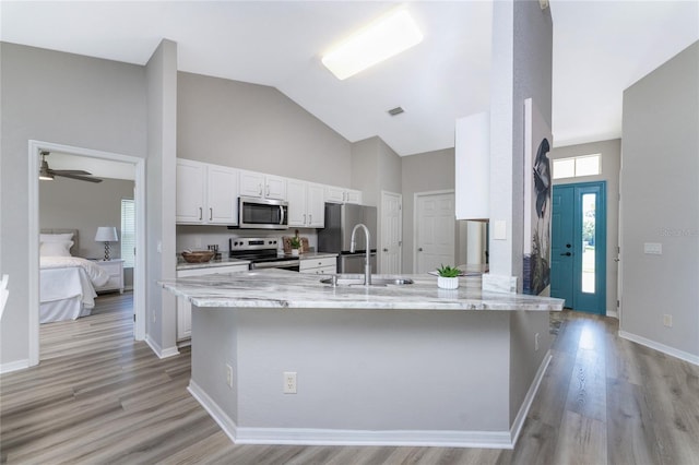 kitchen with ceiling fan, light wood-type flooring, white cabinetry, kitchen peninsula, and stainless steel appliances