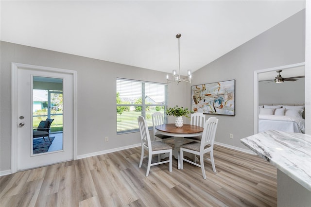 dining area with high vaulted ceiling, ceiling fan with notable chandelier, and light wood-type flooring