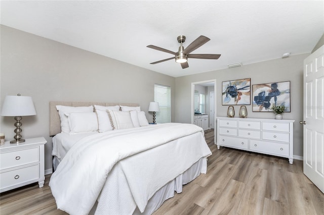 bedroom featuring light hardwood / wood-style floors, ceiling fan, and ensuite bathroom