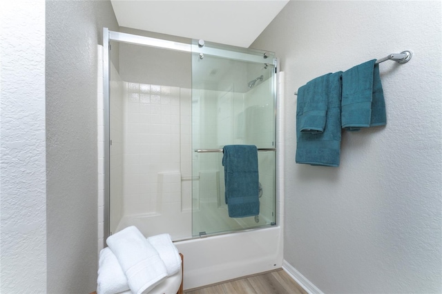 bathroom with shower / bath combination with glass door and hardwood / wood-style floors