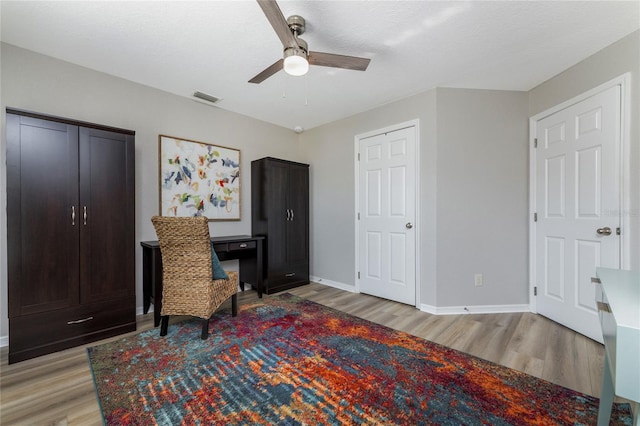 living area featuring light hardwood / wood-style flooring and ceiling fan