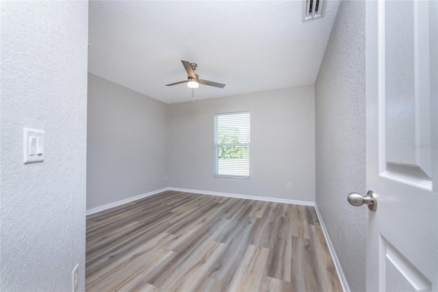 empty room with ceiling fan and hardwood / wood-style floors