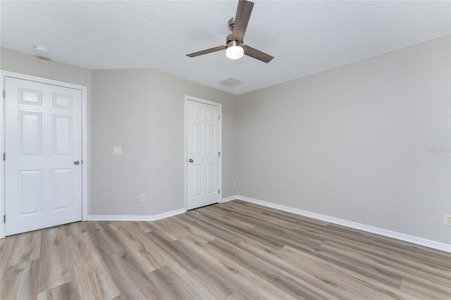 unfurnished bedroom featuring ceiling fan, light hardwood / wood-style floors, and a textured ceiling