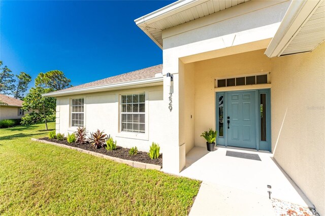 doorway to property featuring a lawn