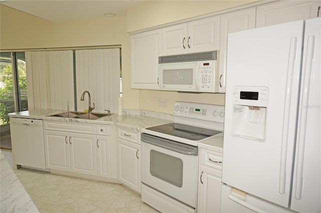 kitchen with sink, white appliances, light tile patterned flooring, and white cabinets