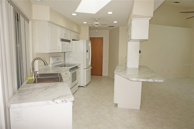 kitchen with sink, a skylight, white appliances, ceiling fan, and white cabinets