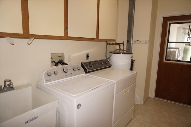 laundry area with light tile patterned flooring, separate washer and dryer, sink, cabinets, and electric water heater