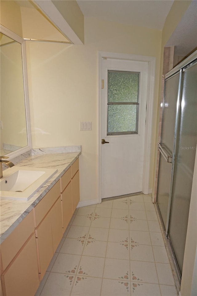 bathroom featuring tile patterned floors, a shower with door, and vanity