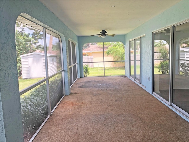 unfurnished sunroom with ceiling fan