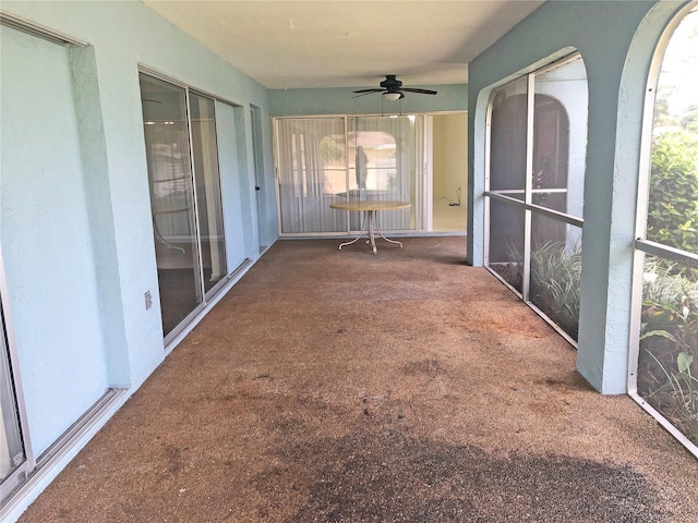 unfurnished sunroom with ceiling fan and a wealth of natural light