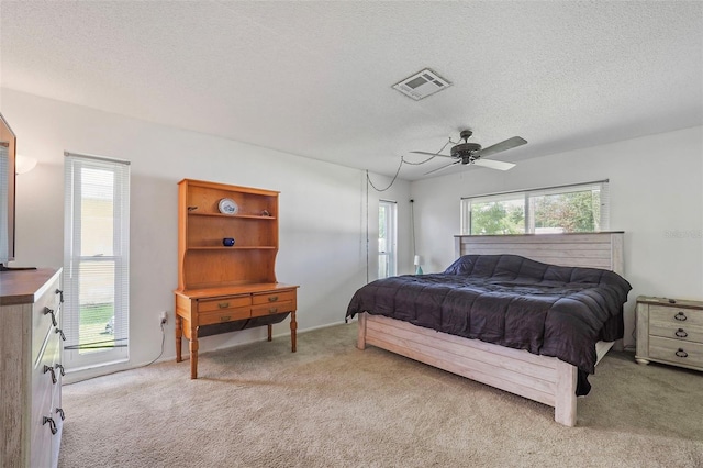 bedroom featuring a textured ceiling, ceiling fan, and carpet floors