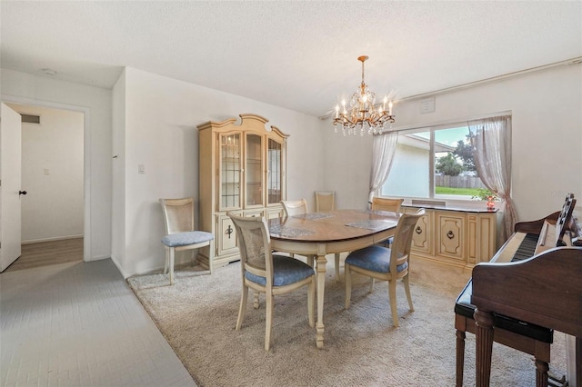 dining room with light colored carpet, a chandelier, and a textured ceiling