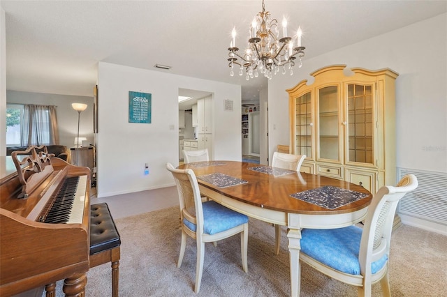 dining space with light colored carpet and a chandelier