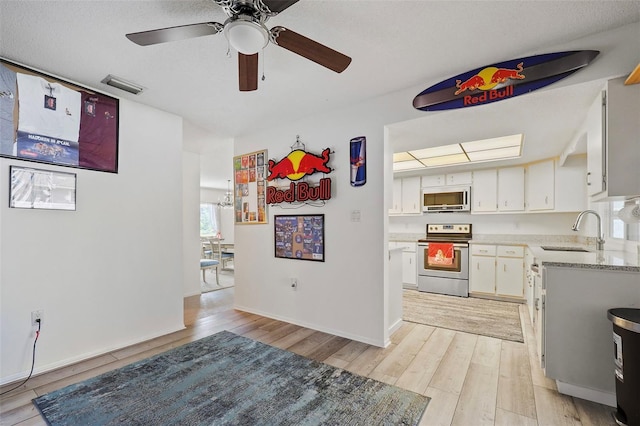 kitchen featuring electric range, sink, white cabinetry, ceiling fan, and light wood-type flooring