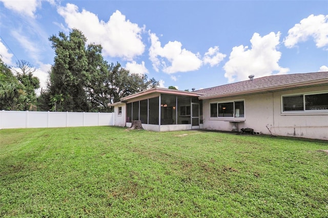 back of property featuring a sunroom and a yard