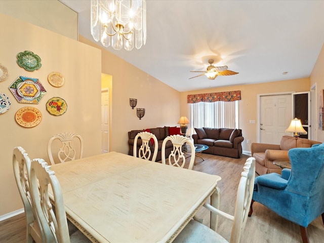 dining area with ceiling fan with notable chandelier and wood-type flooring