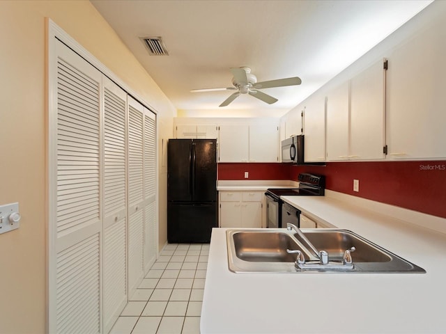 kitchen with black refrigerator, white cabinets, range with electric stovetop, ceiling fan, and light tile patterned flooring