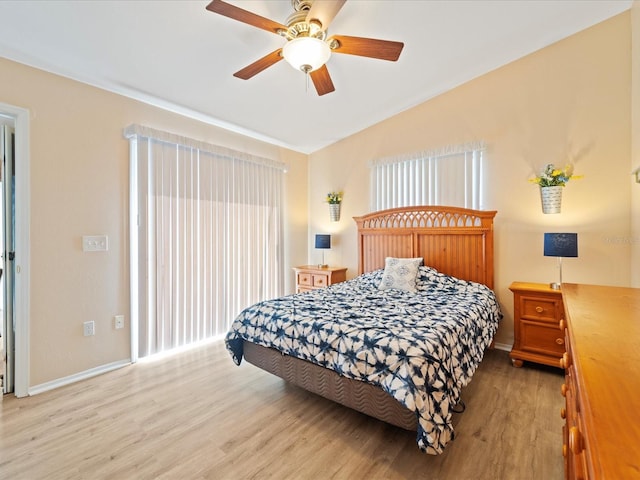 bedroom featuring ceiling fan, light hardwood / wood-style flooring, and lofted ceiling