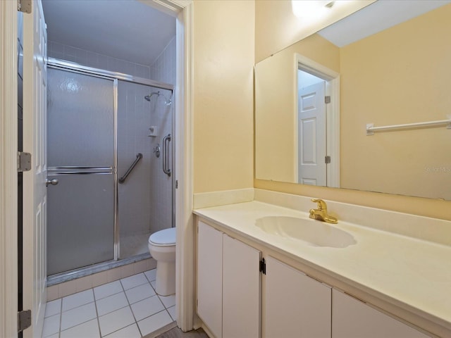 bathroom featuring tile patterned flooring, toilet, vanity, and walk in shower