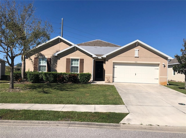 single story home featuring a garage and a front lawn