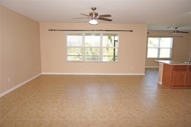 unfurnished room with ceiling fan, sink, and light tile patterned floors