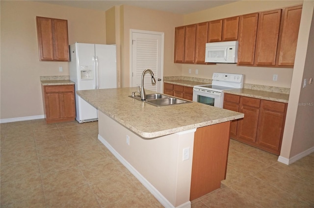 kitchen featuring sink, white appliances, a kitchen island with sink, and light tile patterned floors