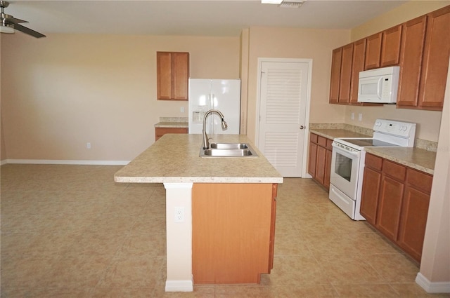 kitchen with sink, an island with sink, white appliances, ceiling fan, and light tile patterned flooring