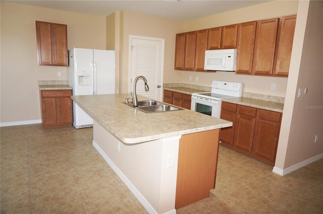 kitchen with white appliances, an island with sink, light tile patterned floors, and sink