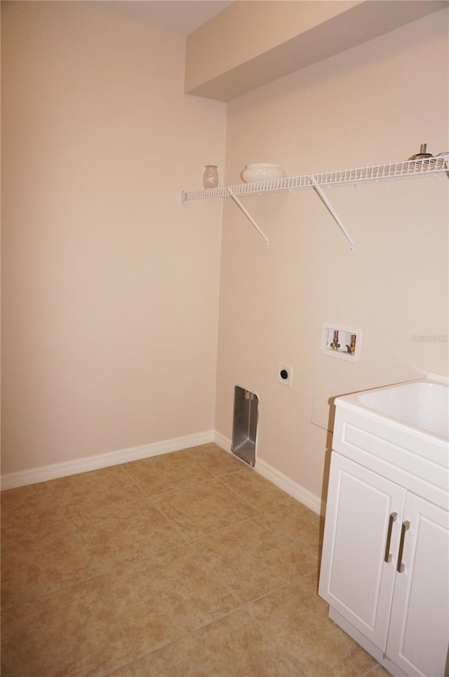 clothes washing area with hookup for an electric dryer, washer hookup, and cabinets