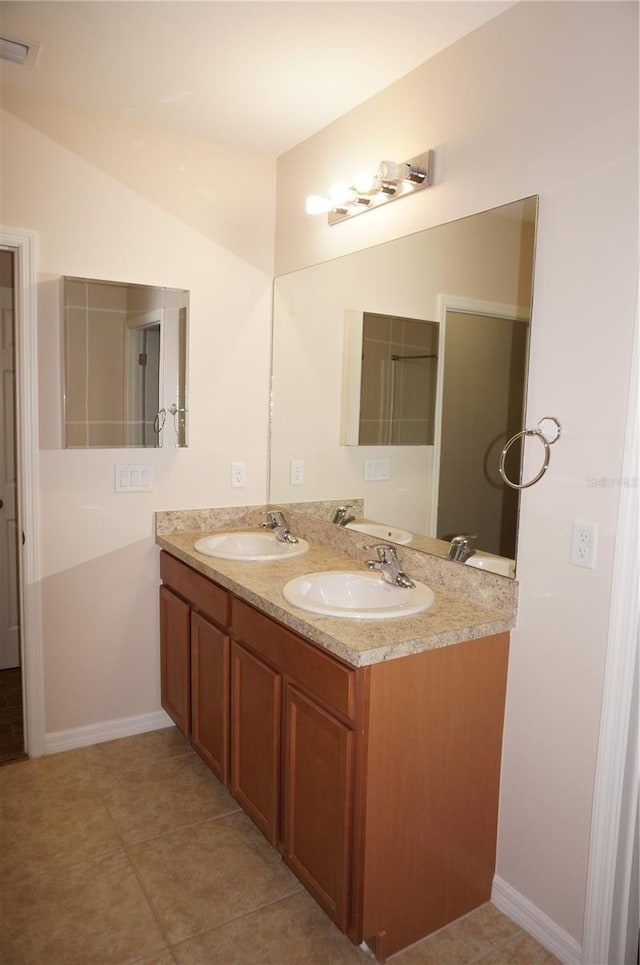 bathroom with tile patterned floors, lofted ceiling, and vanity