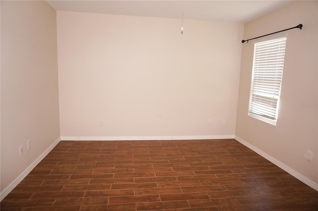 spare room with a wealth of natural light and dark hardwood / wood-style floors