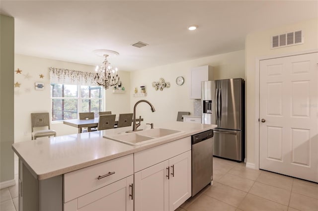 27261 Guapore Dr, Punta Gorda, FL 33983 - kitchen with stainless steel appliances, a sink, a chandelier, and white cabinets