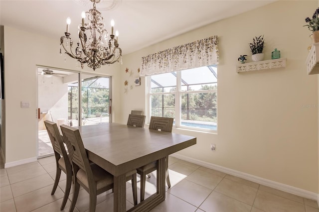 dining area with light tile patterned floors and ceiling fan with notable chandelier