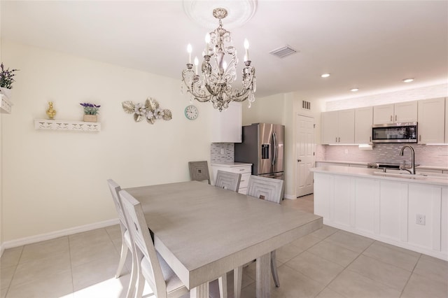 tiled dining room featuring sink and a chandelier