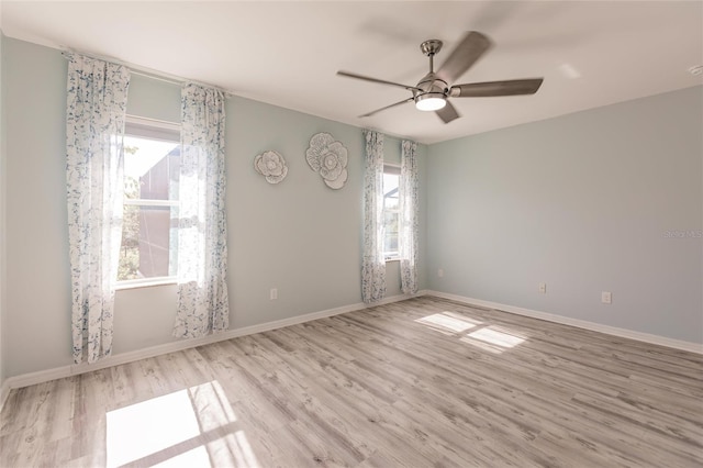 spare room with ceiling fan, light hardwood / wood-style flooring, and a healthy amount of sunlight